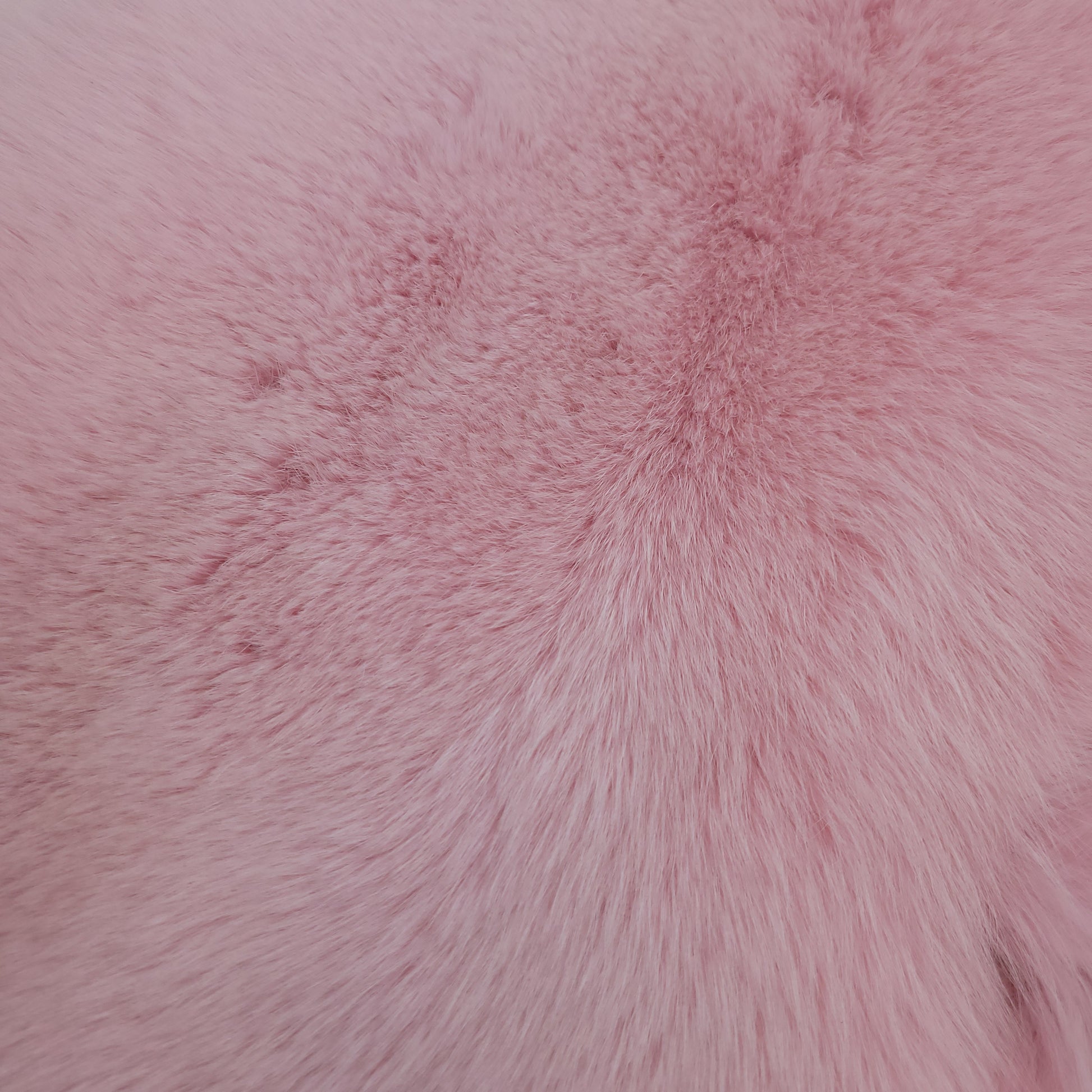 Close-up image of dyed shadow faux fur in baby pink, showing its texture and softness.
